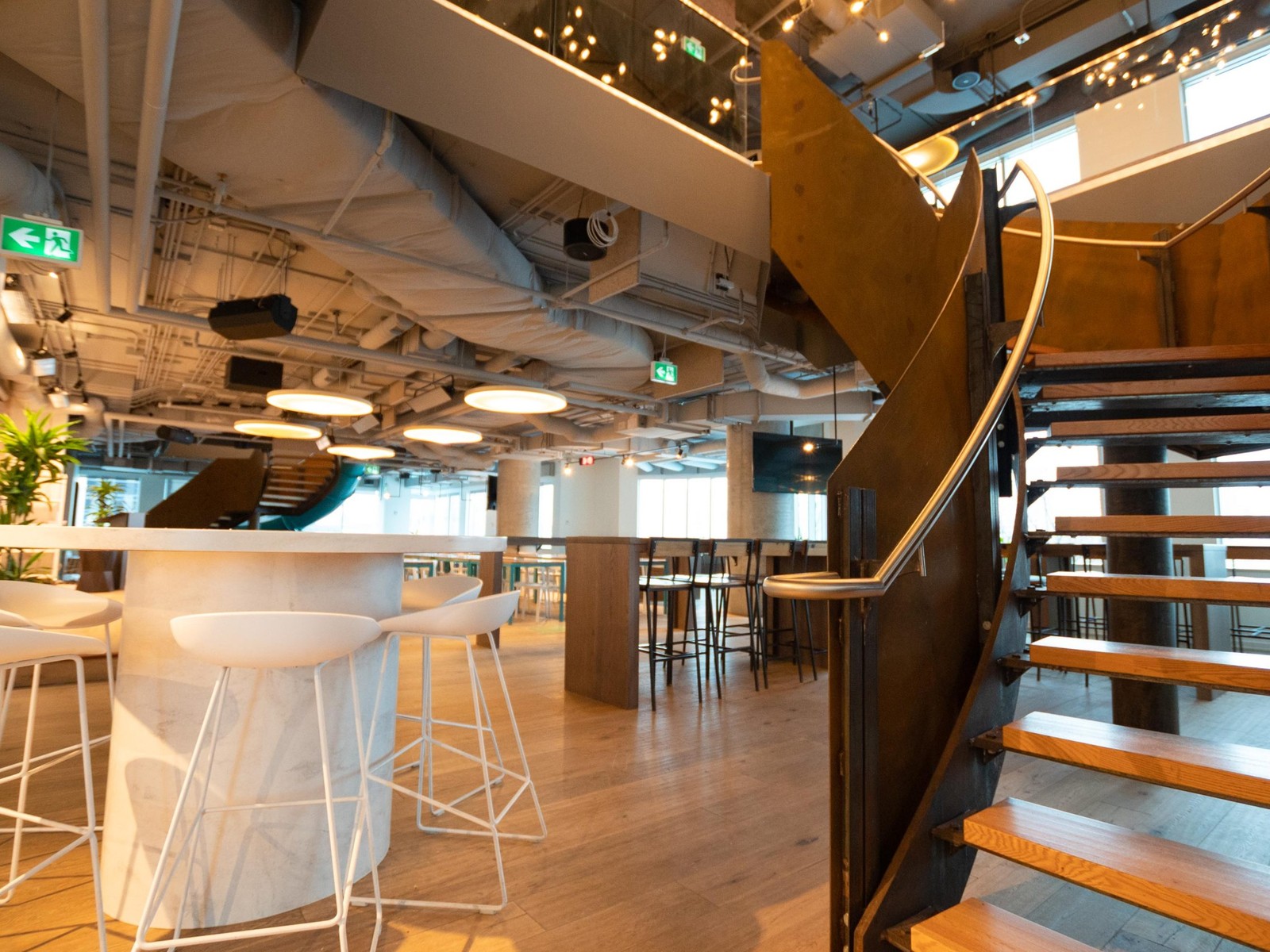 Modern collaborative venue space with staircase and open seating